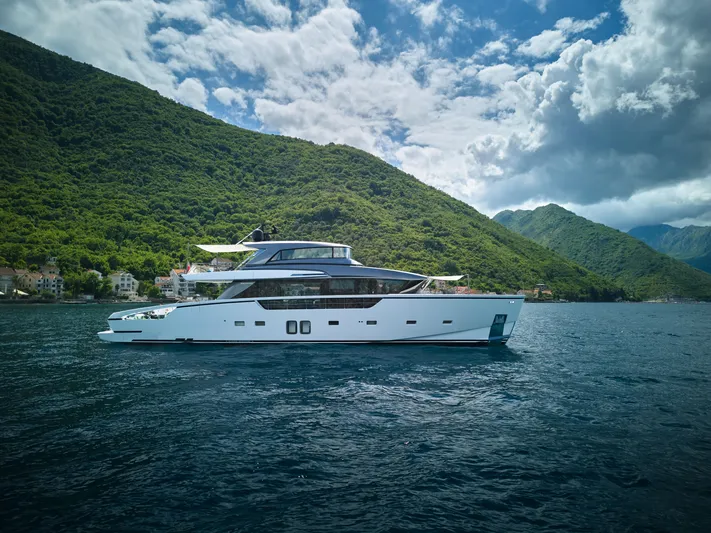  Yacht Photos Pics Luxurious 2020 Sanlorenzo SX88 yacht cruising near lush green hills and blue waters.