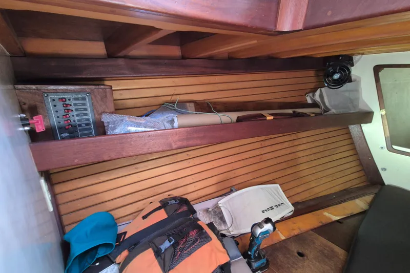 Pearl Yacht Photos Pics Interior of a 1996 Cape George 36 sailboat with wooden paneling and storage shelf.
