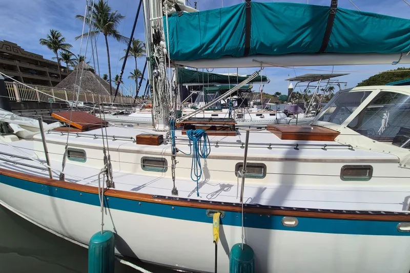 Pearl Yacht Photos Pics Sailboat docked in marina, Cape George 36, 1996 model, with blue accents and tropical backdrop.