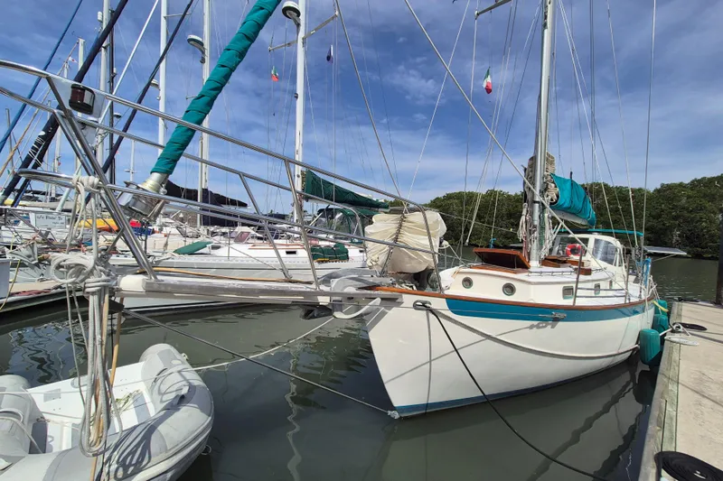 Pearl Yacht Photos Pics Sailboat docked in marina, Cape George 36, 1996 model, with teal accents.