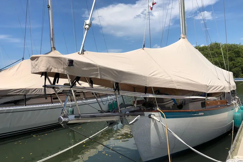 Pearl Yacht Photos Pics 1996 Cape George 36 sailboat docked with protective cover, under a clear blue sky.