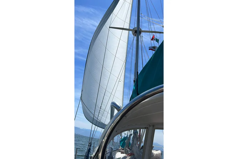 Pearl Yacht Photos Pics Sailing on a 1996 Cape George 36 yacht with full sails under a clear blue sky.