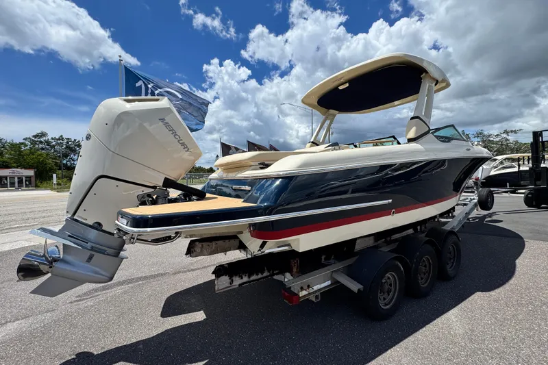  Yacht Photos Pics 2026 Chris-Craft Sportster 28 boat on trailer, featuring Mercury outboard motor, under a blue sky.