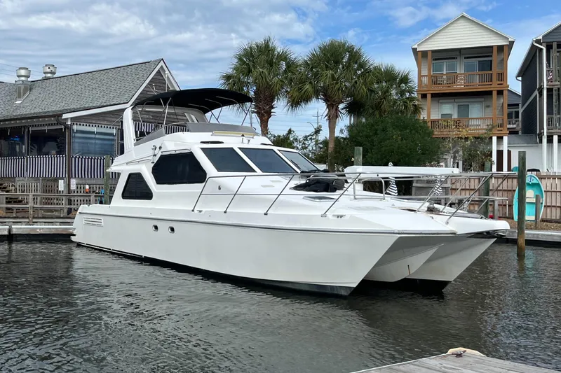 Must B Nice Yacht Photos Pics Custom Sports Catamaran 44, 2001 model, docked near waterfront homes and palm trees.