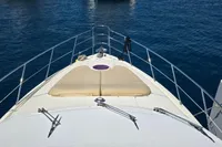Front deck of 2011 Azimut 55 EVOLUTION yacht with sunbathing area on calm water.
