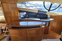 Luxurious kitchen interior of 2011 Azimut 55 EVOLUTION yacht with wood finish and modern appliances.