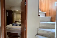 Interior of 2011 Azimut 55 EVOLUTION yacht with cozy bedroom and carpeted stairs.