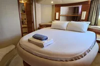 Luxurious bedroom interior of 2011 Azimut 55 EVOLUTION yacht with round bed and elegant decor.