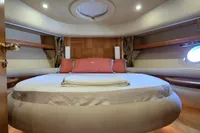 Luxurious bedroom interior of 2011 Azimut 55 EVOLUTION yacht with round bed and porthole.