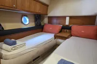 Luxurious twin cabin interior of 2011 Azimut 55 EVOLUTION yacht with porthole view.