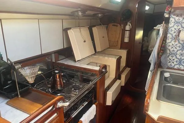 Pickle Yacht Photos Pics 1989 Hylas 44 yacht interior kitchen with stove, sink, and storage compartments.