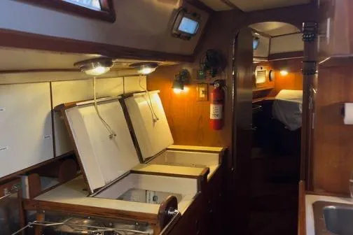 Pickle Yacht Photos Pics 1989 Hylas 44 yacht interior with open storage, wood finish, and cozy lighting.