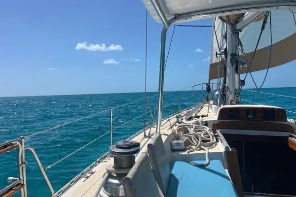 Pickle Yacht Photos Pics Sailing on a 1989 Hylas 44 yacht in clear blue ocean waters under a sunny sky.