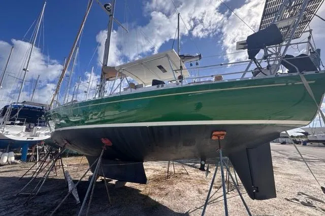 Pickle Yacht Photos Pics 1989 Hylas 44 sailboat on stands, green hull, under a partly cloudy sky.
