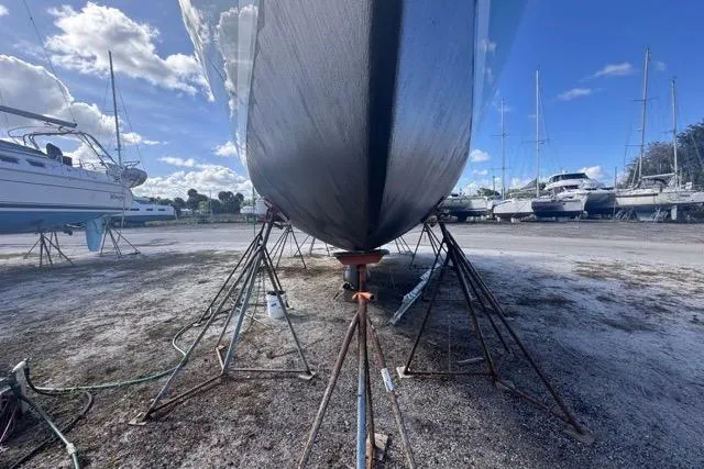 Pickle Yacht Photos Pics Hylas 44 sailboat from 1989 on stands in a boatyard under a blue sky.