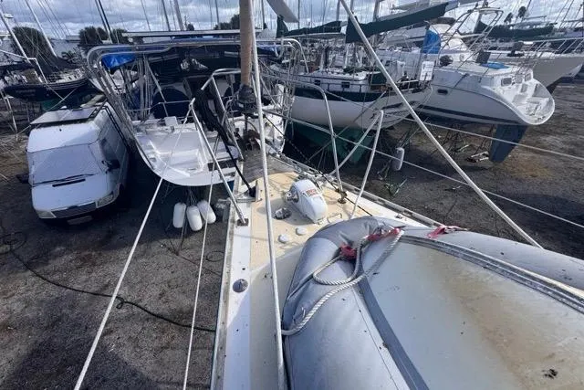 Pickle Yacht Photos Pics Sailboat Hylas 44 (1989) in dry dock, surrounded by other boats and a van.