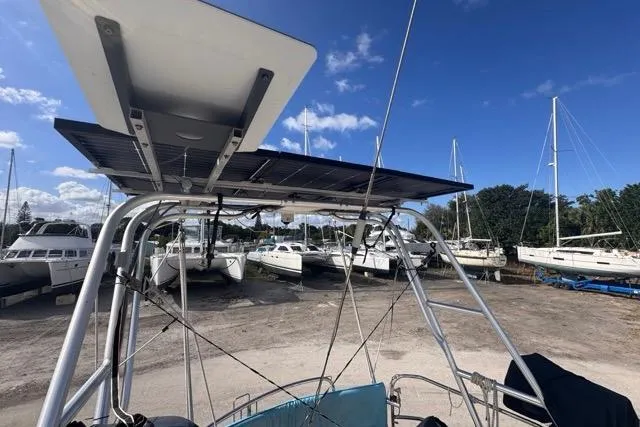Pickle Yacht Photos Pics Sailboat with solar panel, Hylas 44, 1989 model, docked in a marina under clear blue sky.