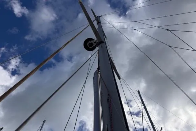 Pickle Yacht Photos Pics Mast of 1989 Hylas 44 sailboat against a cloudy sky.