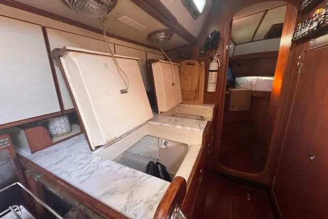 Pickle Yacht Photos Pics Interior of 1989 Hylas 44 yacht with open storage compartments and wooden finishes.