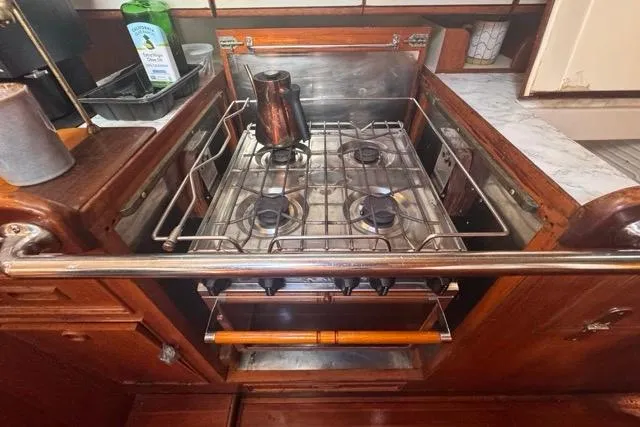 Pickle Yacht Photos Pics Galley kitchen in 1989 Hylas 44 yacht with stove and wooden cabinetry.