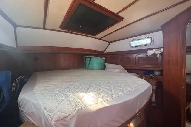 Pickle Yacht Photos Pics Cozy cabin interior of 1989 Hylas 44 sailboat with bed and wooden paneling.