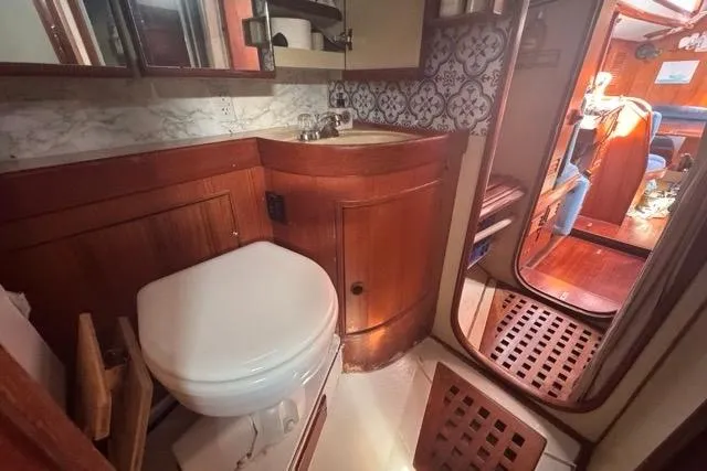 Pickle Yacht Photos Pics 1989 Hylas 44 yacht bathroom with wooden cabinetry and nautical decor.