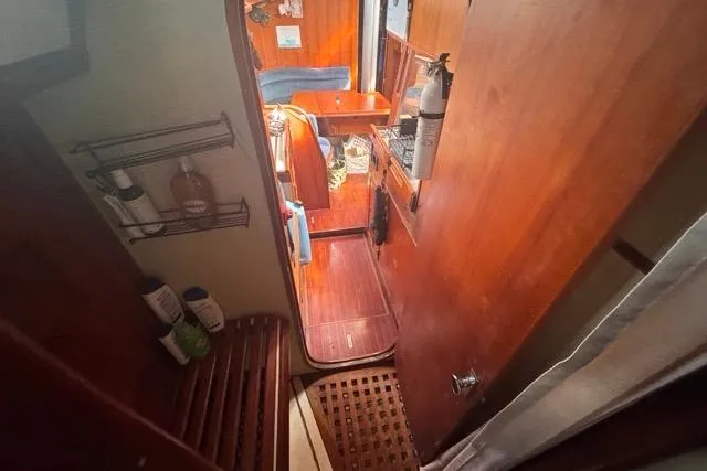 Pickle Yacht Photos Pics Interior view of 1989 Hylas 44 sailboat, featuring wooden cabinetry and cozy seating area.