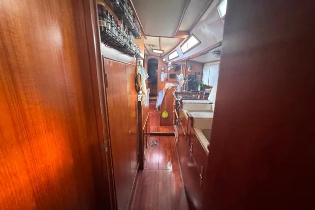 Pickle Yacht Photos Pics Interior view of 1989 Hylas 44 sailboat with wooden cabinetry and cozy layout.