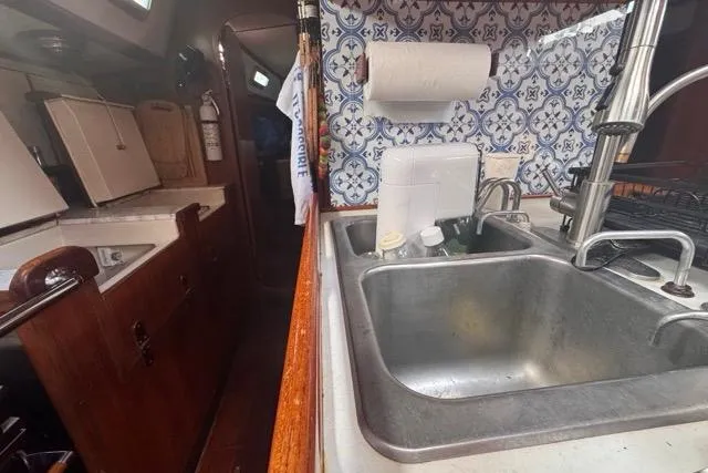 Pickle Yacht Photos Pics Interior of 1989 Hylas 44 yacht kitchen with sink and patterned backsplash.