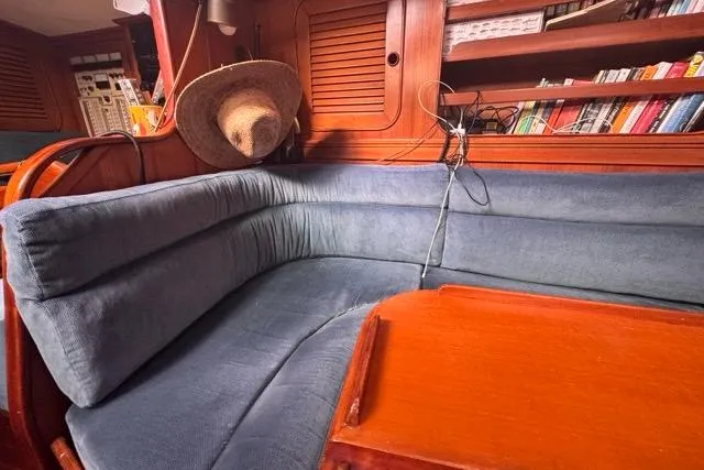 Pickle Yacht Photos Pics Cozy interior of 1989 Hylas 44 yacht with blue seating and wooden accents.