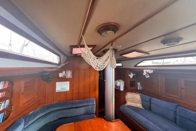 Pickle Yacht Photos Pics Interior of 1989 Hylas 44 sailboat with cozy seating and wooden finishes.
