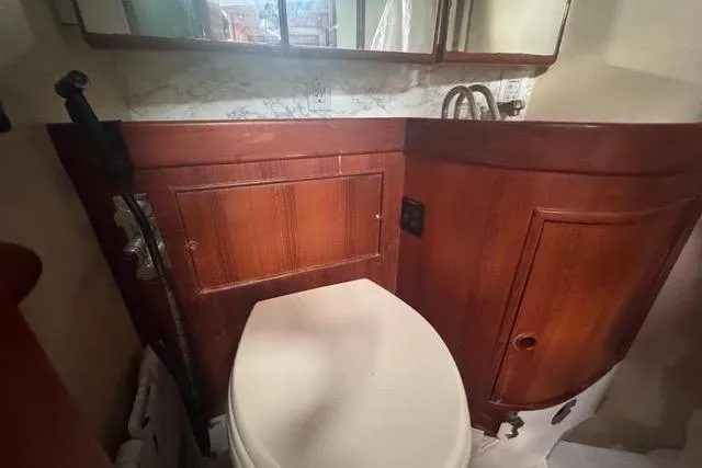 Pickle Yacht Photos Pics 1989 Hylas 44 yacht bathroom with wooden cabinetry and white toilet.