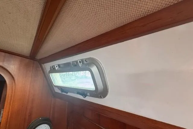 Pickle Yacht Photos Pics Interior of 1989 Hylas 44 sailboat with wooden paneling and porthole window.