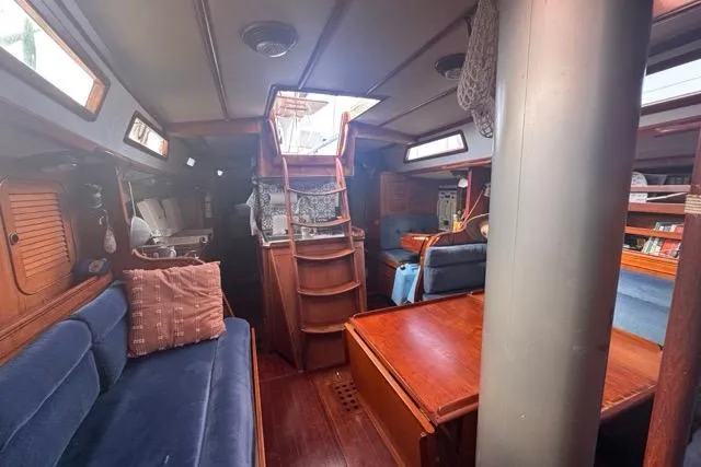Pickle Yacht Photos Pics Interior of 1989 Hylas 44 sailboat with wooden furnishings and blue seating.
