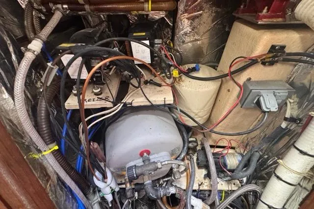 Pickle Yacht Photos Pics Engine compartment of a 1989 Hylas 44 sailboat with various mechanical components.