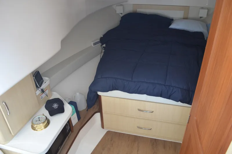  Yacht Photos Pics 2023 Regal 36 Grande Coupe cabin interior with bed, storage, and wooden flooring.