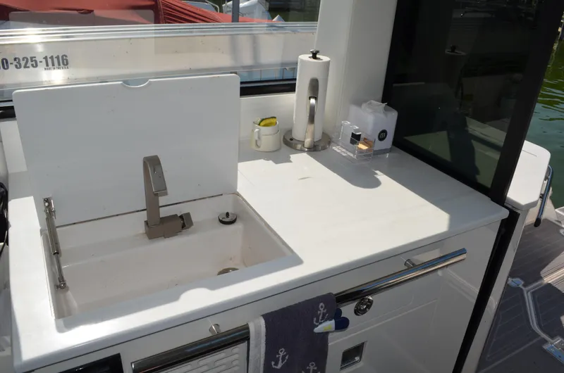  Yacht Photos Pics 2023 Regal 36 Grande Coupe yacht kitchenette with sink and countertop accessories.