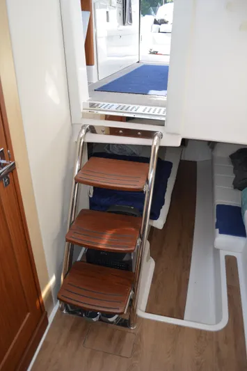 Yacht Photos Pics Staircase inside 2023 Regal 36 Grande Coupe yacht, featuring wooden steps and modern design.