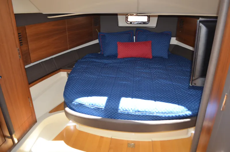  Yacht Photos Pics 2016 Chris-Craft Launch 36 cabin with blue bedding and wooden interior.