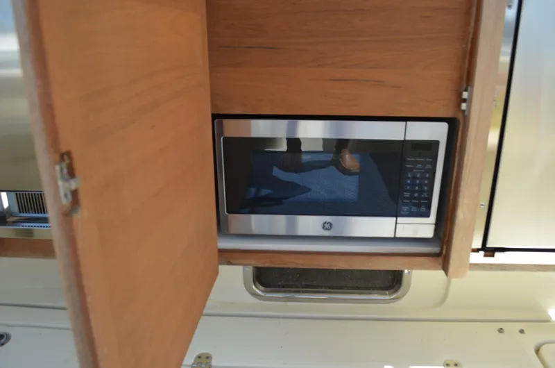  Yacht Photos Pics 2016 Chris-Craft Launch 36 interior with built-in microwave behind wooden cabinet door.