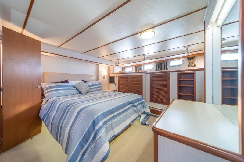 Sumo Yacht Photos Pics Luxurious bedroom interior of 1991 Tollycraft 57 Pilothouse Motor Yacht with striped bedding.