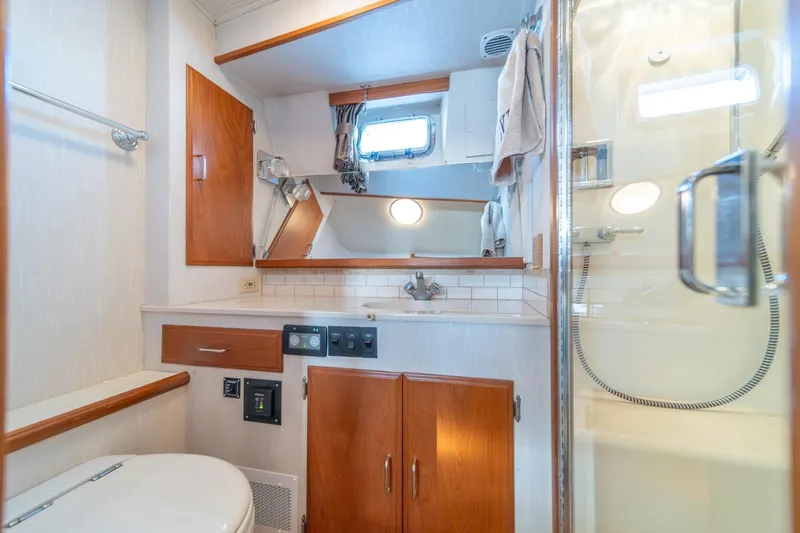 Sumo Yacht Photos Pics Bathroom interior of 1991 Tollycraft 57 Pilothouse Motor Yacht, featuring wood cabinetry and shower.