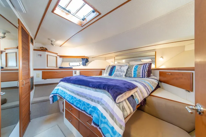 Sumo Yacht Photos Pics Luxurious bedroom interior of 1991 Tollycraft 57 Pilothouse Motor Yacht with cozy bedding.