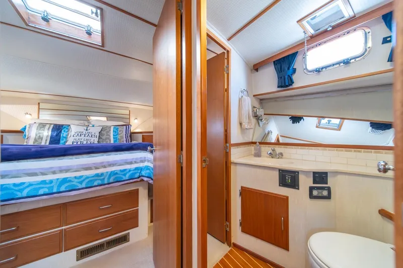 Sumo Yacht Photos Pics Luxurious 1991 Tollycraft 57 Pilothouse Motor Yacht cabin with cozy bed and ensuite bathroom.