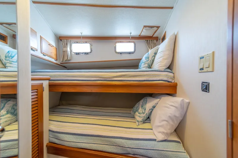 Sumo Yacht Photos Pics Bunk beds in 1991 Tollycraft 57 Pilothouse Motor Yacht cabin, featuring striped bedding.