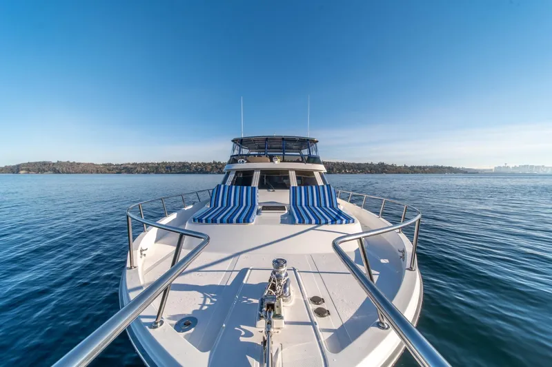 Sumo Yacht Photos Pics 1991 Tollycraft 57 Pilothouse Motor Yacht on calm water, featuring striped deck chairs.