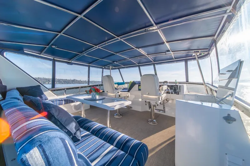 Sumo Yacht Photos Pics Luxurious 1991 Tollycraft 57 Pilothouse Motor Yacht interior with blue seating and panoramic views.