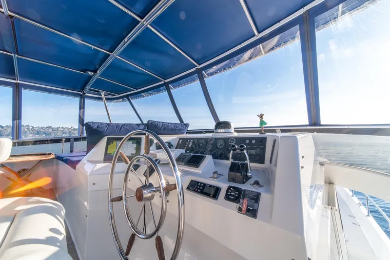 Sumo Yacht Photos Pics 1991 Tollycraft 57 Pilothouse Motor Yacht helm with blue canopy and scenic view.