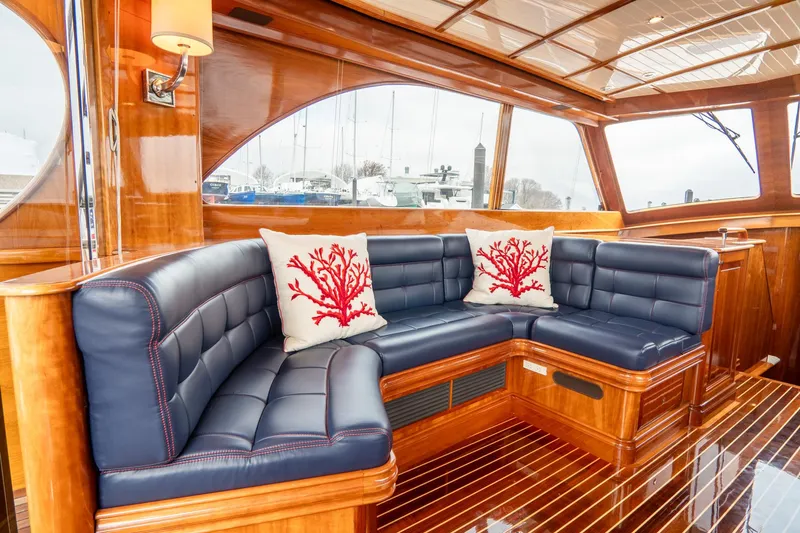 Sapphire II Yacht Photos Pics Luxurious interior of 2006 Hinckley Talaria 55 FB yacht with navy seating and coral-themed pillows.