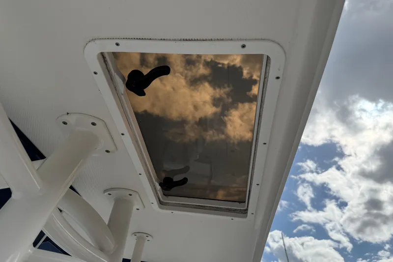 Big Blue Yacht Photos Pics Hatch on 2017 Century 3200 Center Console boat reflecting cloudy sky.
